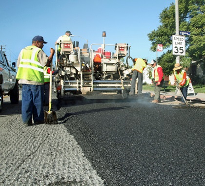 Road workers laying asphalt