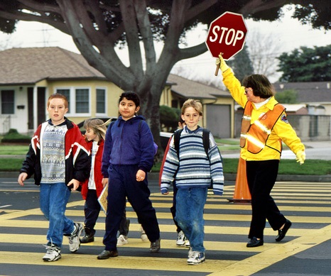 Crossing guard escorting school children across Woodruff Avenue