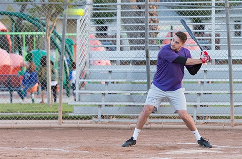 Man holding bat ready to swing at baseball