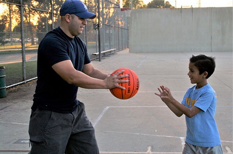 Coach giving basketball to boy
