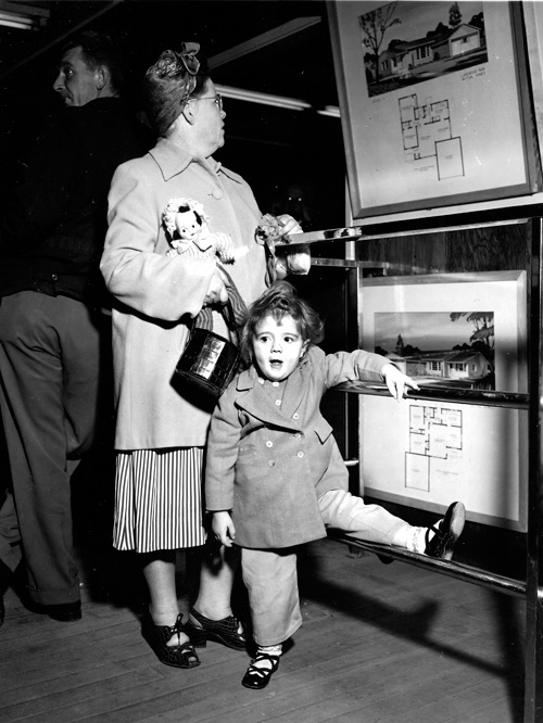 Mother and daughter looking at house plans in 1950