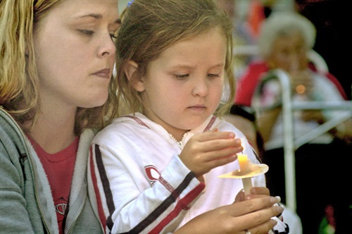Mother and daughter holding a candle