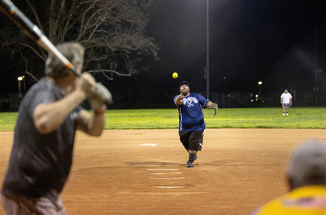 Man pitches softball to batter