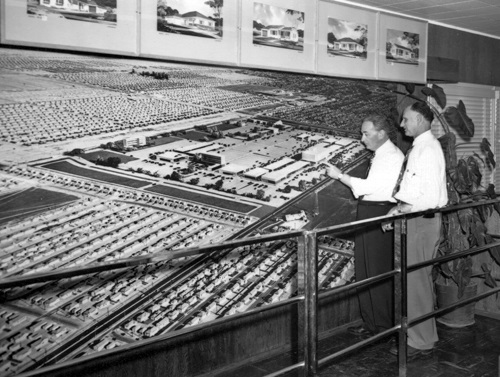 Men standing in front of a giant mural of Lakewood in 1951
