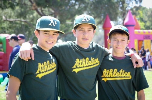 Three young baseball players on the Athletics team