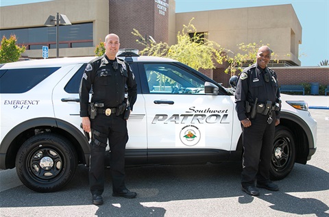 Security guards next to Southwest Patrol car with Lakewood logo