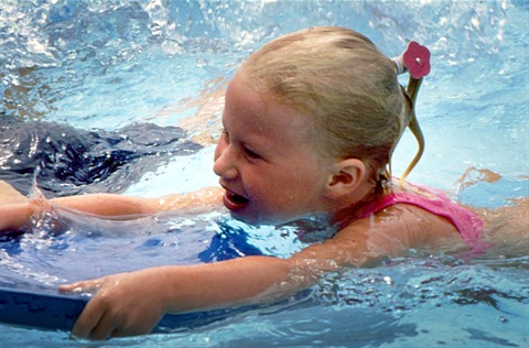 child on swim board in pool
